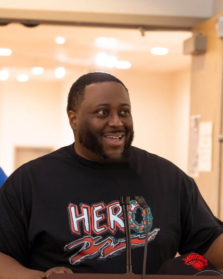 Catalyst CT mentor Tyese Williams smiles as he speaks at a podium